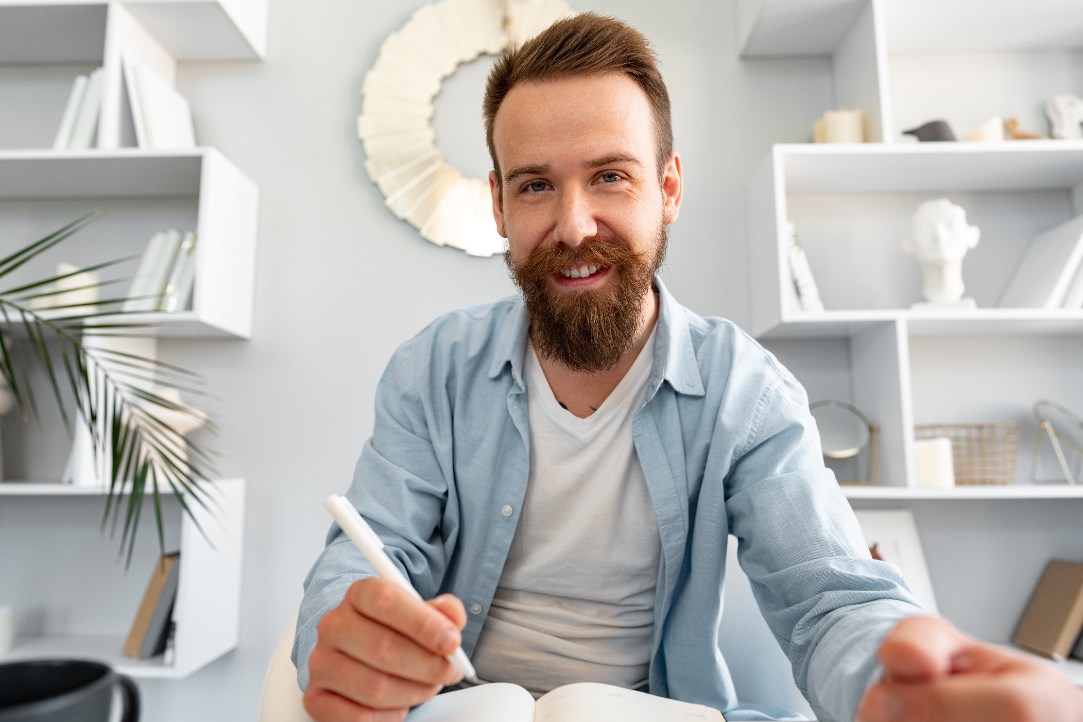 young bearded man sitting at the desk and taking n ap4slgl.jpg