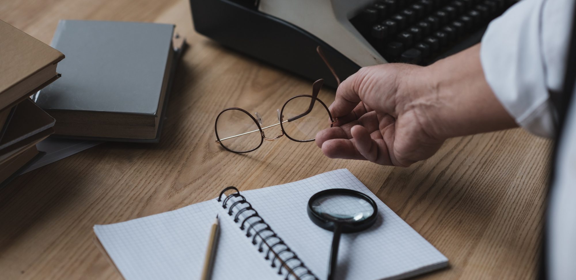 senior writer putting eyeglasses on work desk