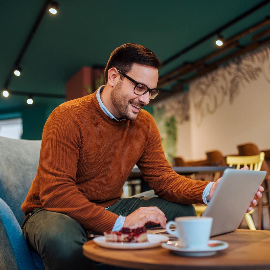 cheerful man using laptop in a cozy restaurant po 2024 10 18 07 51 26 utc 1 1 cropped.jpg