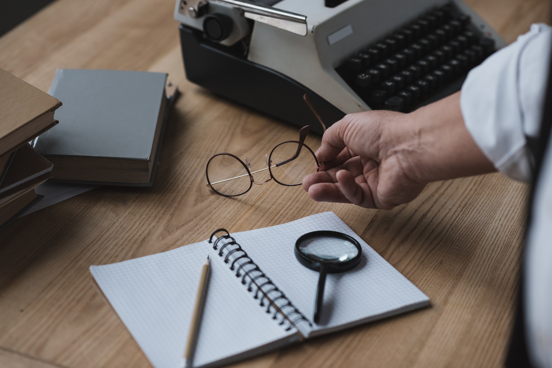 senior writer putting eyeglasses on work desk w7gav6z.jpg