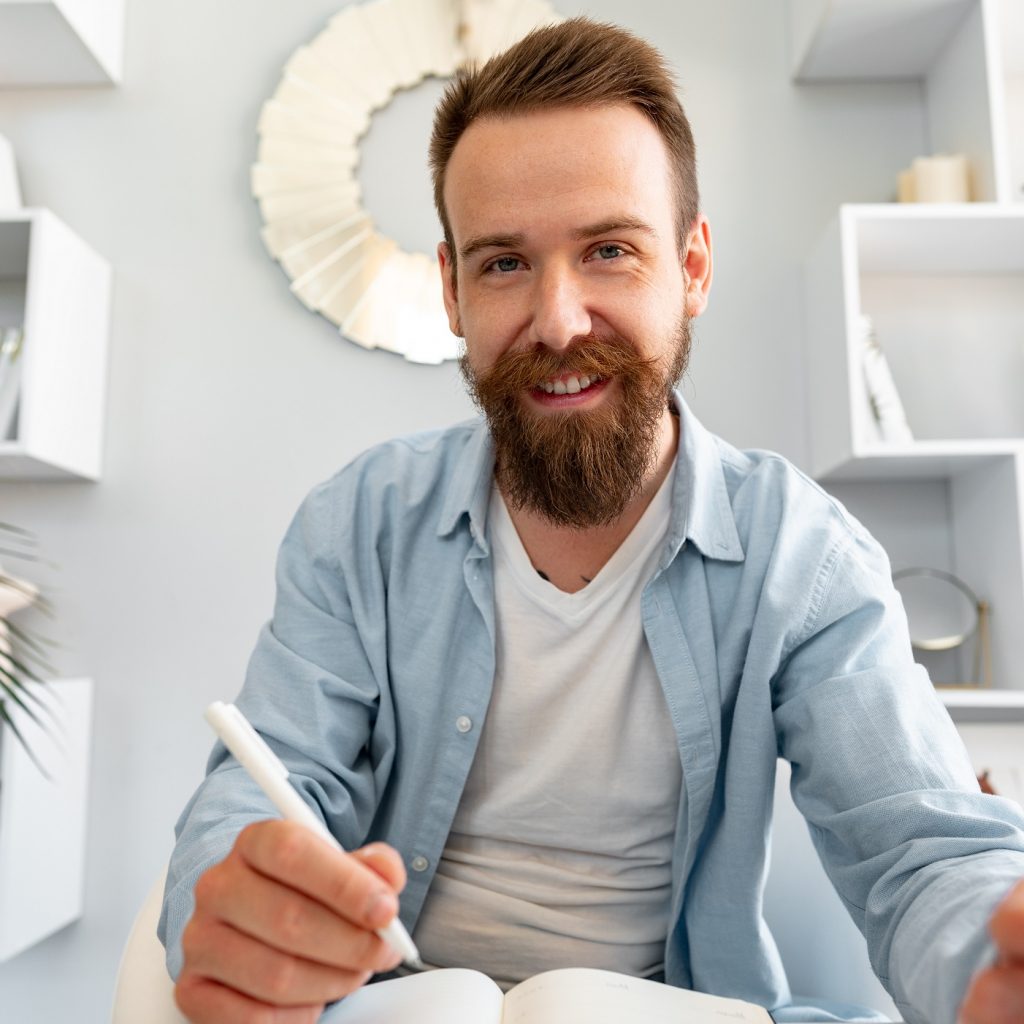 young bearded man sitting at the desk and taking n ap4slgl.jpg